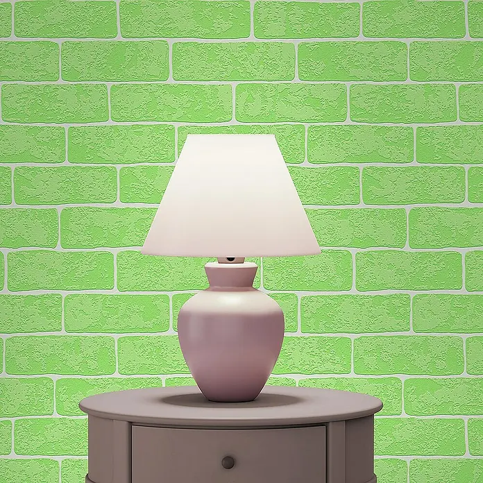 Tadessi Vliestapete M1-No.2619 - Weiß, Steinoptik, 10,05 x 0,53 m - Eine rosa-weiße Lampe steht auf einem grauen runden Beistelltisch vor einer grünen Ziegelwand.