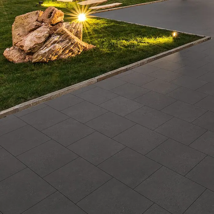 EHL Terrassenplatte Mantina - 60 x 40 x 4 cm, Anthrazit, Beton - Pflastersteine im Außenbereich mit Gras und Beleuchtung. Ideal für Gartenwege oder Terrassen, die ein modernes Ambiente suchen.