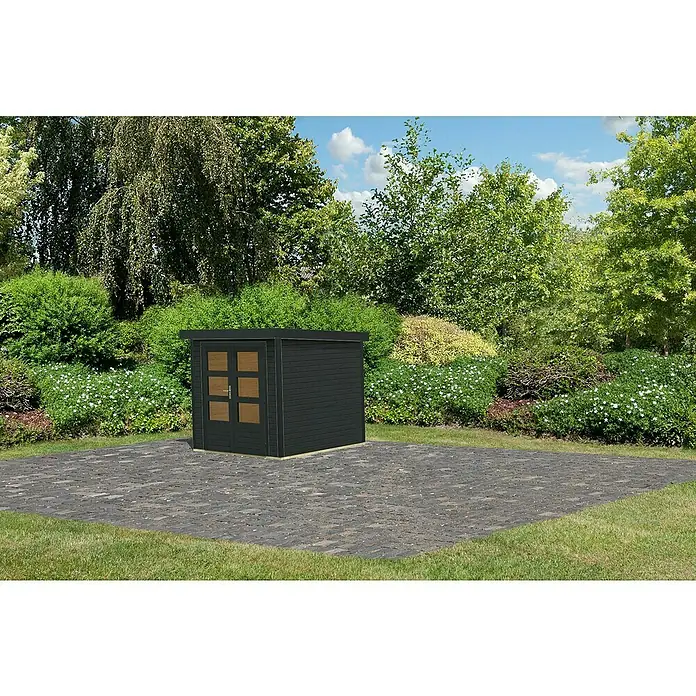 Karibu Gerätehaus Locknell Express - Außenmaß inkl. Dachüberstand (B x T): 228,5 x 235 cm, Holz, Anthrazit - Moderne, schwarze Gartensauna mit Holztüren und Glasfenstern auf gepflasterter Fläche, umgeben von grüner Vegetation und Bäumen.