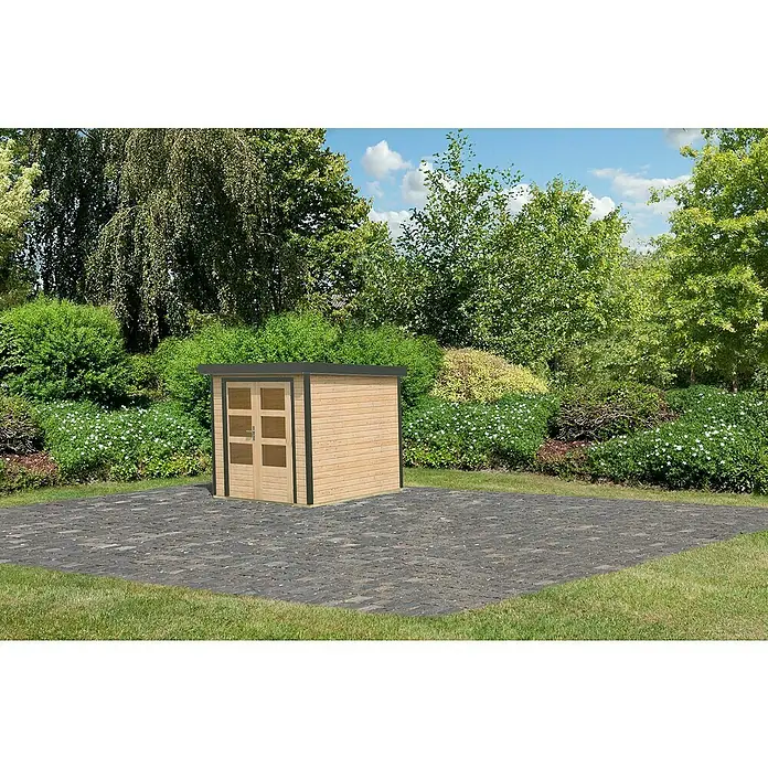 Karibu Gerätehaus Locknell Express - Außenmaß inkl. Dachüberstand (B x T): 228,5 x 235 cm, Holz, Naturbelassen/Anthrazit - Ein kleines Holzgartenhaus mit Doppeltüren steht auf einem gepflasterten Bereich, umgeben von üppigem Grün und Bäumen.