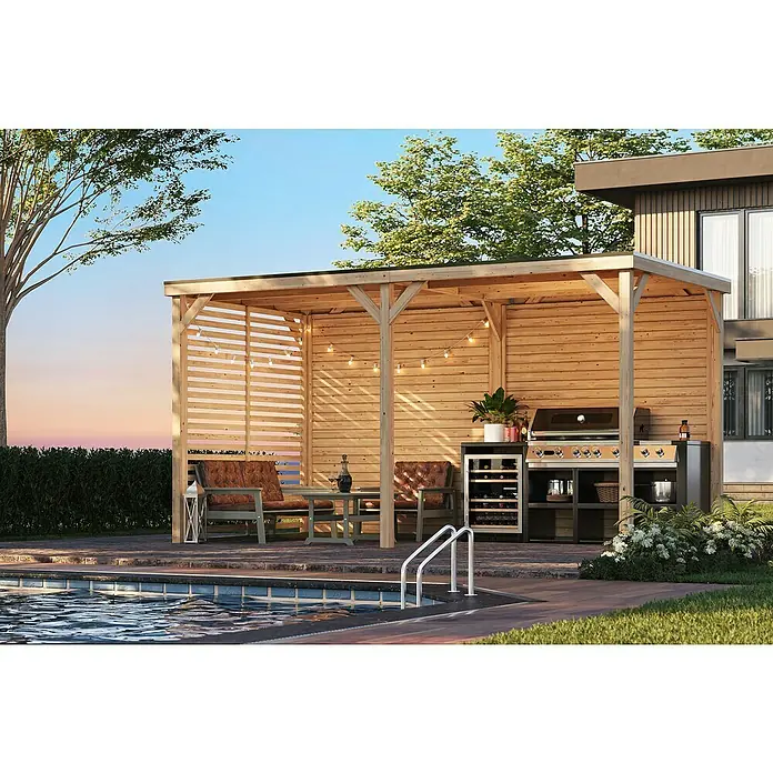 Karibu Gartenpavillon Toscana - 464 x 242 cm, Holz, Naturbelassen, Mit Lamellen-Seitenwand & Rückwand - Eine geräumige Grillstation mit Sitzbereich unter einer hölzernen Pergola neben einem einladenden Pool für entspannte Stunden im Freien.