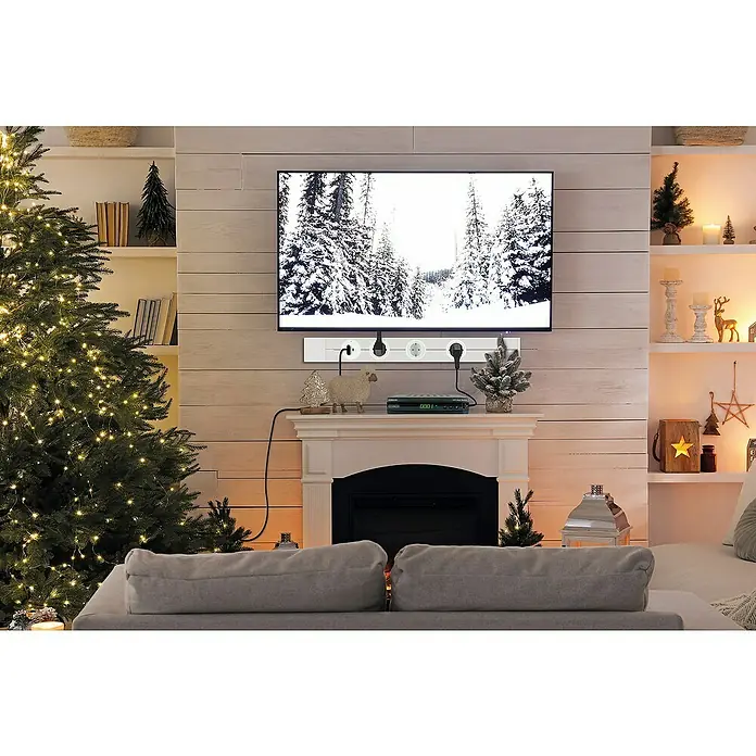 Schwaiger Steckdosenleiste Modulare Stromschiene - 75 cm, Weiß, IP20, Ohne Schalter - Eine Mehrfachsteckdose mit mehreren Steckdosen ist unter einem an der Wand montierten Fernseher angebracht.