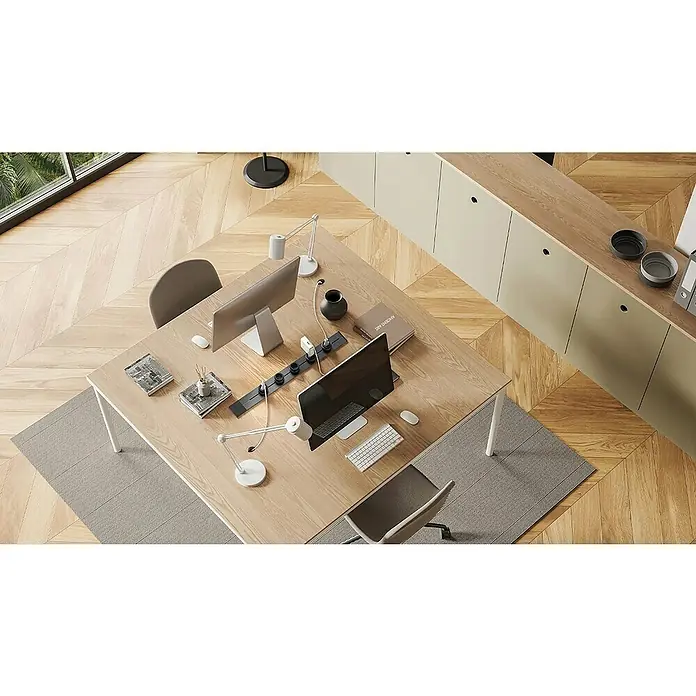 Schwaiger Steckdosenleiste Modulare Stromschiene - 75 cm, Schwarz, IP20, Ohne Schalter - Schreibtisch mit Computern und Büromaterial. Der Tisch steht auf einem hellen Teppich in einem Raum mit hellem Holzboden.
