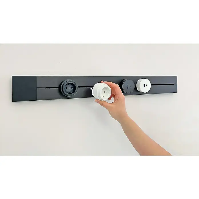 Schwaiger USB-Steckdose Adapter USB-A, USB-C - 6,2 cm, Schwarz - Das Bild zeigt eine modulare Steckdosenleiste an einer weißen Wand, bei der eine Steckdose von einer Hand eingesetzt wird.