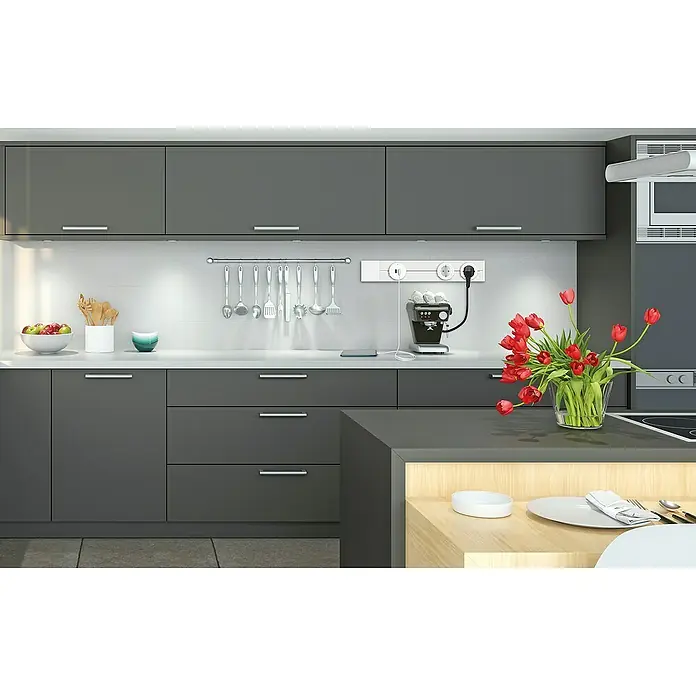 Schwaiger Steckdosenleiste Modulare Stromschiene - 50 cm, Weiß, IP20, Ohne Schalter - Moderne Küche mit grau lackierten Schränken, einer Kücheninsel und einer Vase roter Tulpen als Dekoration.