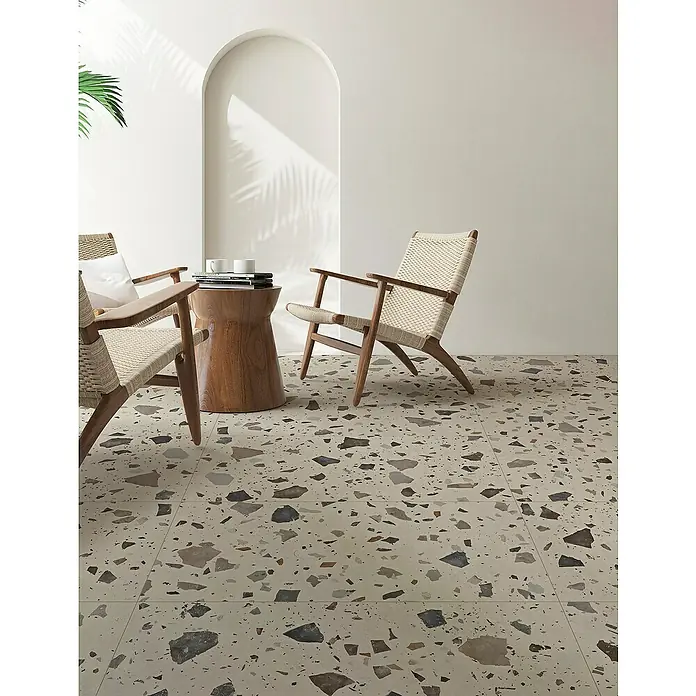 Feinsteinzeugfliese Pebble - 59,55 x 59,55 cm, Ivory, Matt - Elegantes Interieur mit Terrazzoboden, der dem Raum einen stilvollen und modernen Look verleiht. Zwei Sessel laden zum Verweilen ein.