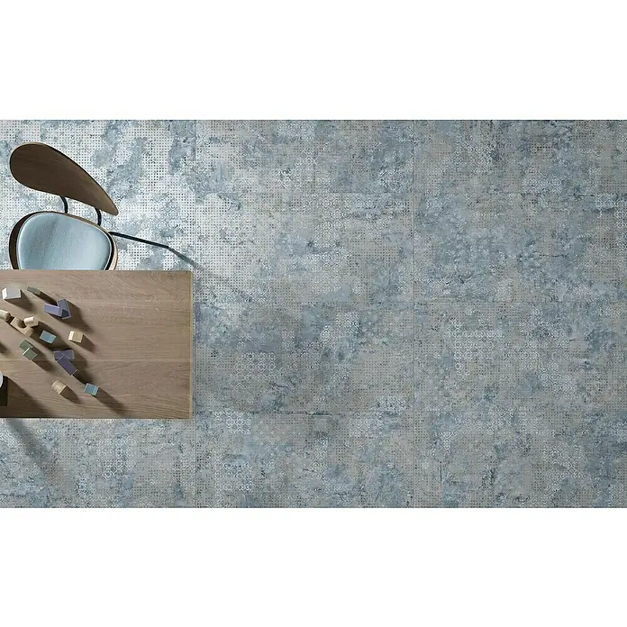 Feinsteinzeugfliese Rug - 59,55 x 59,55 cm, Blue, Matt - Dekorative Bodenfliesen in einem Mix aus Blau- und Grautönen mit subtilen Mustern, kombiniert mit einem Holztisch und Stuhl für ein stilvolles Interieur.