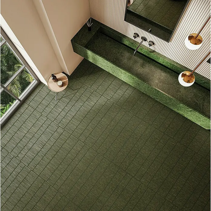 Feinsteinzeugfliese Wanda - 59,55 x 59,55 cm, Green, Matt - Badezimmer-Ansicht von oben mit einem langen, grünen Waschbecken und einem passenden Bodenbelag. Hängende Lampen und Fenster ergänzen das Design.