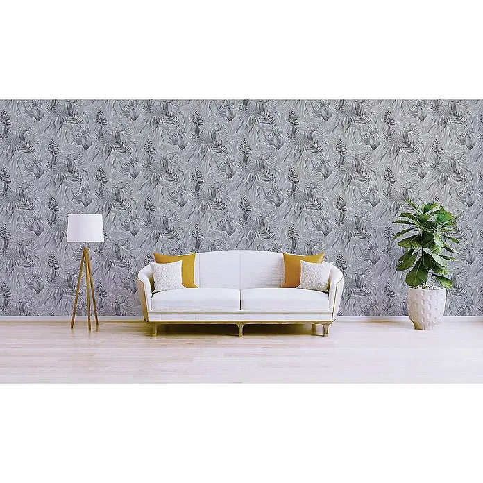 Tadessi Vliestapete M1-No.251 - Schwarz, Floral, 10,05 x 0,53 m - Grau-weiß gemusterte Tapete mit tropischen Blättern in einem modernen Wohnzimmer mit hellem Sofa und Pflanze.