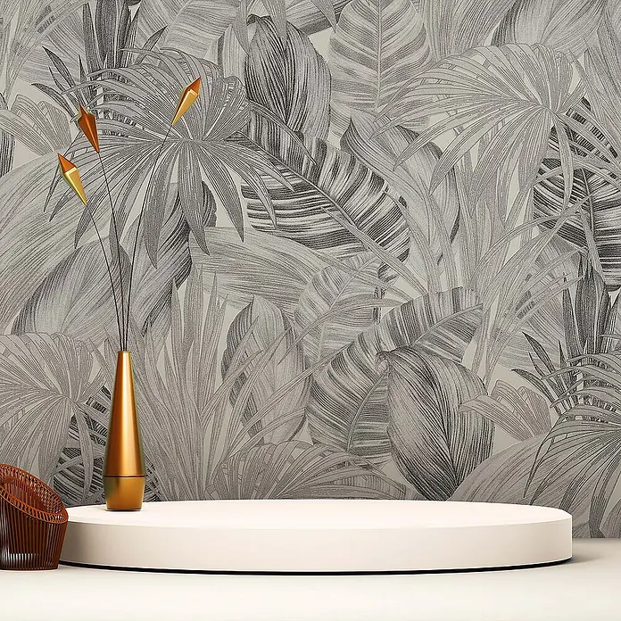 Tadessi Vliestapete M1-No.251 - Schwarz, Floral, 10,05 x 0,53 m - Weißer runder Produktständer mit goldener Vase und geflochtenem Stuhl vor grauer Blättertapete.