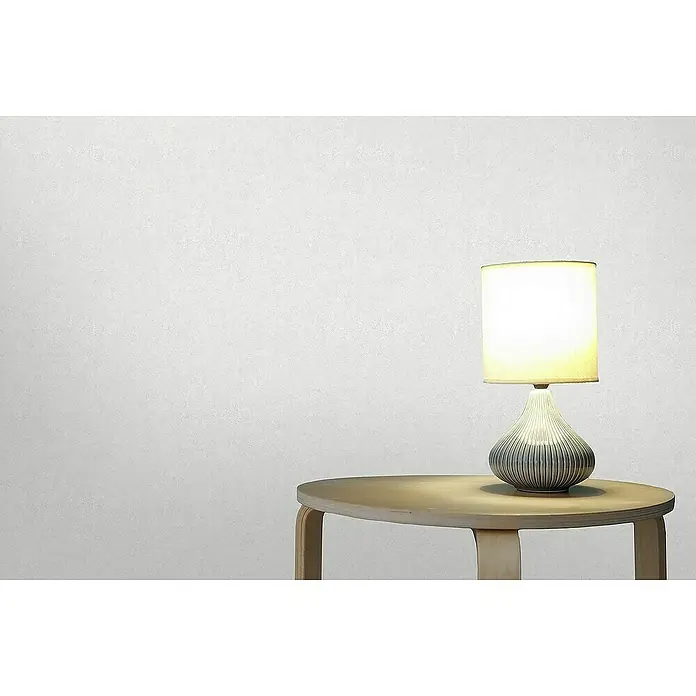 Tadessi Vliestapete M1-No.4406 - Grau, Sonstiges, 10,05 x 0,53 m - Beleuchtete Tischlampe mit weißem Schirm und geripptem grauem Fuß auf ovalem hellen Holztisch.