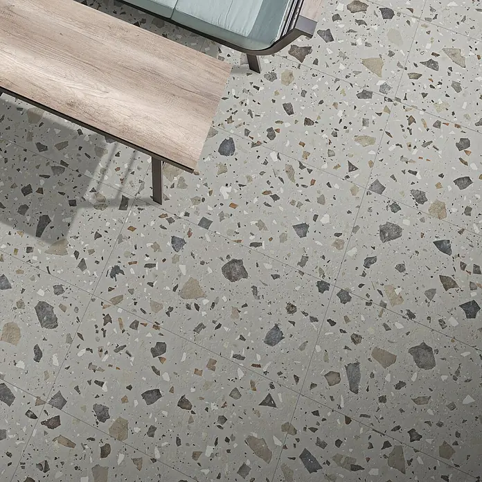 Feinsteinzeugfliese Pebble - 59,55 x 59,55 cm, Grey, Matt - Nahaufnahme von Terrazzo-Fliesen auf dem Boden, die ein einzigartiges und modernes Design präsentieren.