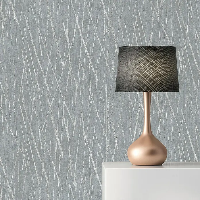 Tadessi Vliestapete M1-No.1711 - Grau, Streifen, 10,05 x 0,53 m - Roségoldene Tischlampe mit dunklem strukturiertem Lampenschirm auf weißer Oberfläche.