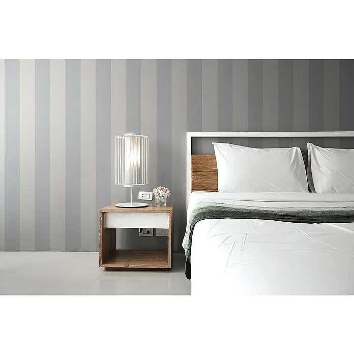 Tadessi Vliestapete M1-No.2041 - Weiß, Streifen, 10,05 x 0,53 m - Ein modernes Schlafzimmer mit weißem Bett, Holz-Kopfteil und stilvollem Nachttisch. Eine weiße Lampe und Blumen stehen auf dem Tisch.