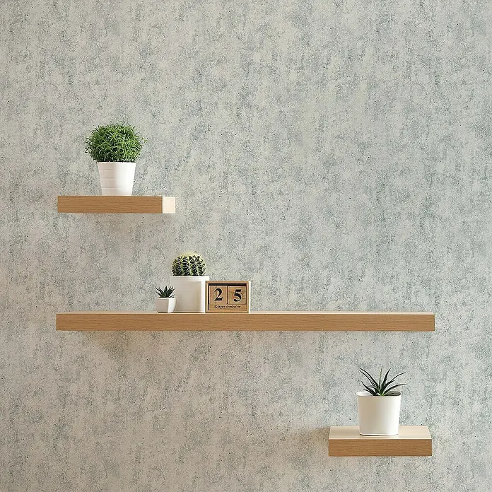 Tadessi Vliestapete M1-No.163 - Grau, Steinoptik, 10,05 x 0,53 m - Drei helle Holz-Wandregale sind an einer Wand montiert und tragen Topfpflanzen sowie einen Holzkalender. Sie bieten stilvolle, platzsparende Präsentation.
