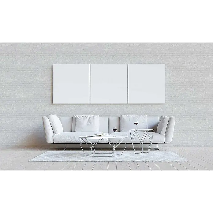 Tadessi Vliestapete M1-No.3233 - Weiß, Steinoptik, 10,05 x 0,53 m - Drei leere weiße Leinwände nebeneinander über einem modernen weißen Sofa in einem minimalistischen Wohnzimmer.