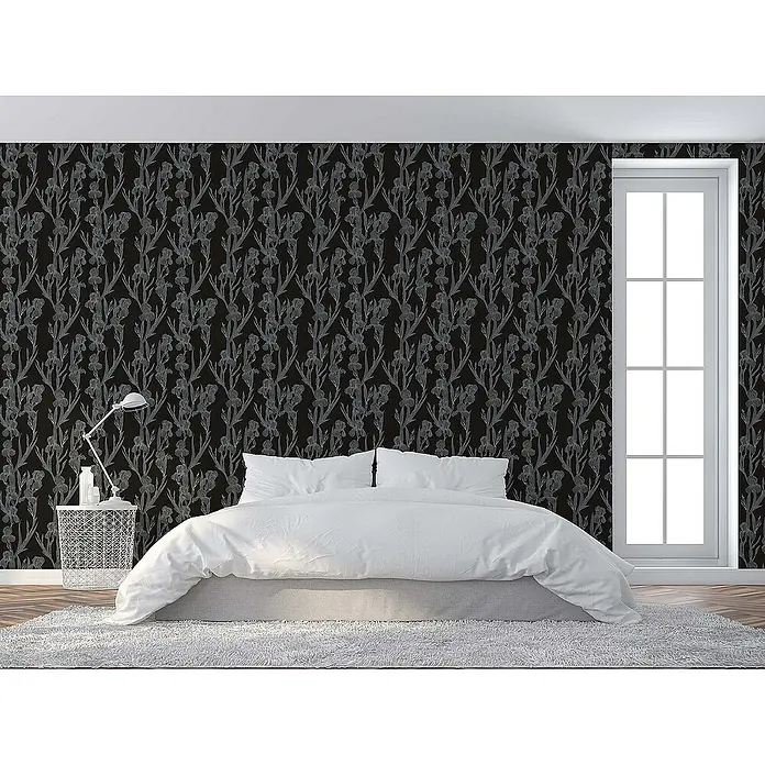 Tadessi Vliestapete M1-No.1375 - Schwarz, Floral, 10,05 x 0,53 m - Dunkle Tapete mit hellgrauem Irisblütenmuster an einer Schlafzimmerwand hinter einem weißen Bett.