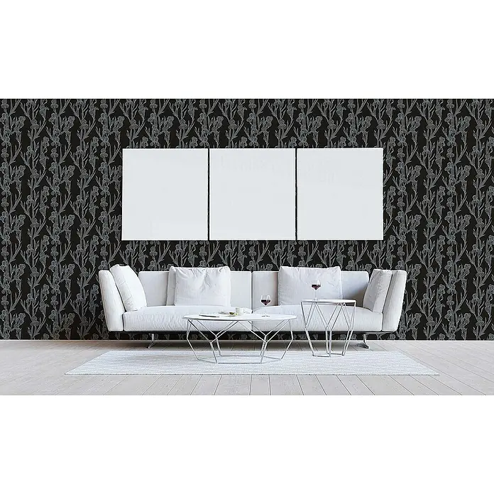 Tadessi Vliestapete M1-No.1375 - Schwarz, Floral, 10,05 x 0,53 m - Schwarze Tapete mit hellgrauem Irisblumenmuster an einer Wohnzimmerwand hinter einem weißen Sofa.