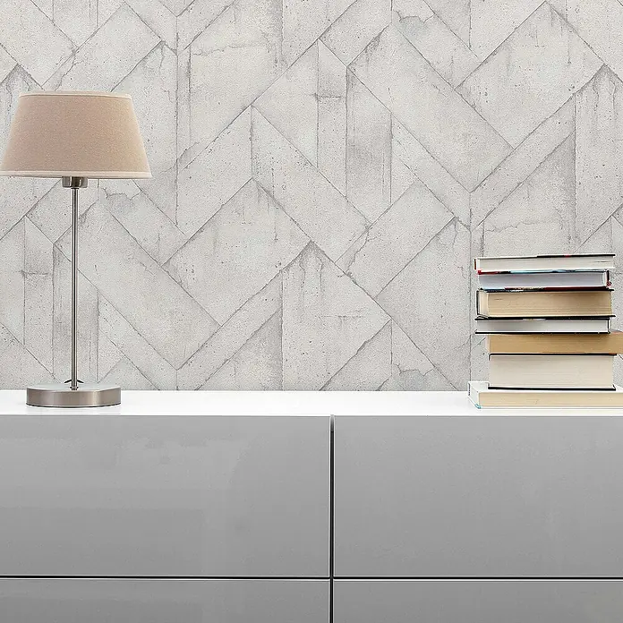 Tadessi Vliestapete M1-No.544 - Grau, Steinoptik, 10,05 x 0,53 m - Modernes graues Sideboard mit beiger Tischlampe und Büchern auf der Oberfläche.