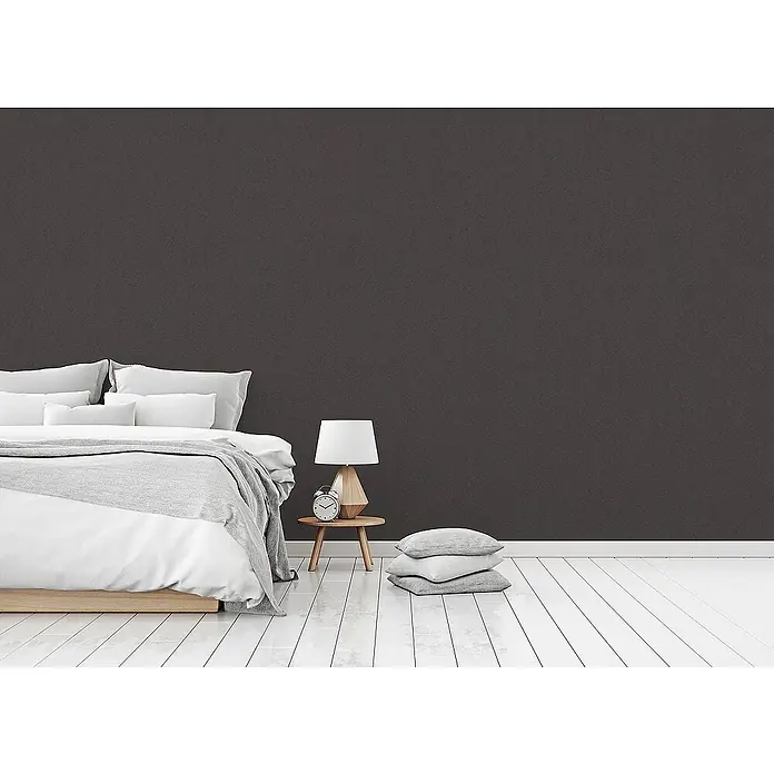 Tadessi Vliestapete M1-No.1031 - Schwarz, Uni, 10,05 x 0,7 m - Dunkelbraune strukturierte Wandverkleidung in einem modernen Schlafzimmer hinter einem Bett.