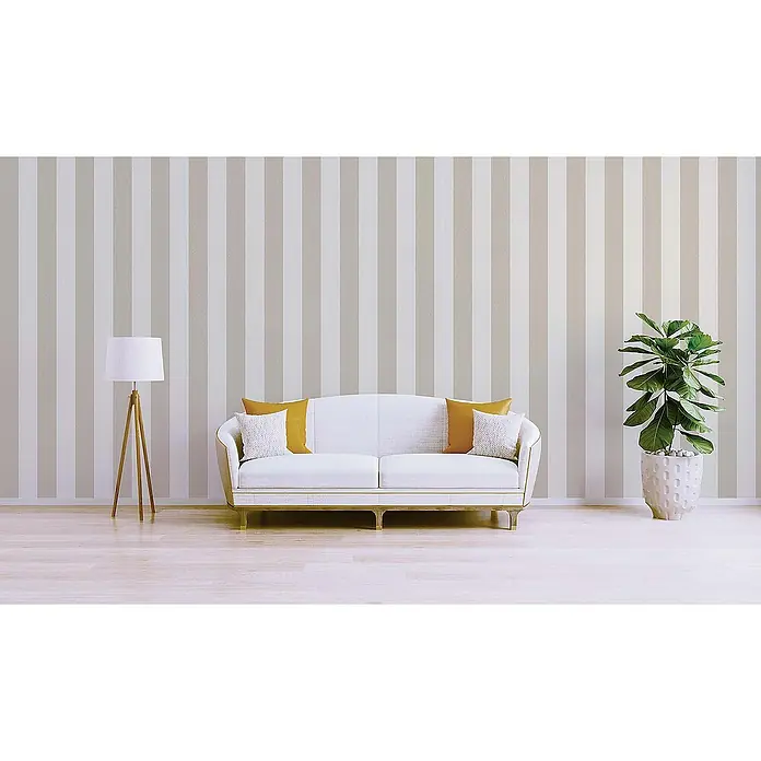 Tadessi Vliestapete M1-No.480 - Creme, Streifen, 10,05 x 0,53 m - Ein weißes Sofa mit goldenen Akzenten, gelben und weißen Kissen, steht in einem Raum mit gestreifter Tapete, Stehlampe und Pflanze.