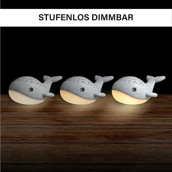 LED-Nachtlicht Wal Willy - L x B x H: 17 x 8,9 x 14 cm, RGBW - Drei stufenlos dimmbare Wal-Nachtlichter aus grauem Kunststoff stehen auf einem Holztisch.