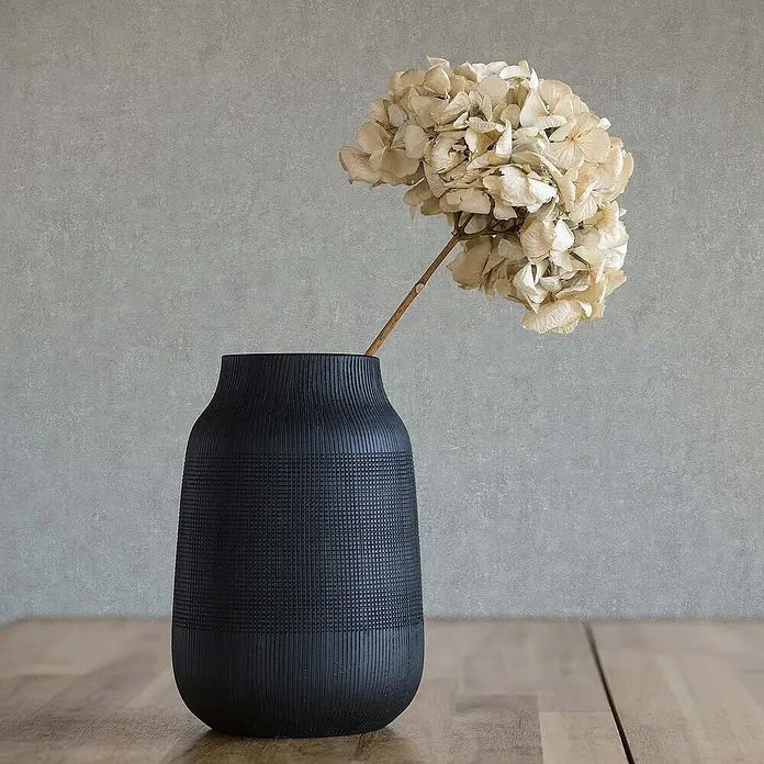 Tadessi Vliestapete M1-No.1814 - Grau, Steinoptik, 10,05 x 0,53 m - Dunkle, texturierte Vase mit getrockneter Hortensie auf einem Holztisch.