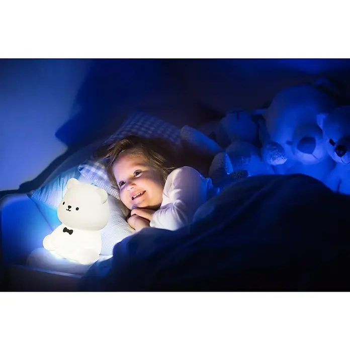 FHL easy LED-Nachtlicht Karl - 0,8 W, L x B x H: 10 x 10 x 13 cm, RGBW, Bär Karl - Lächelndes Kind im Bett mit einem leuchtenden, niedlichen Bären Nachtlicht, das eine beruhigende Atmosphäre schafft.