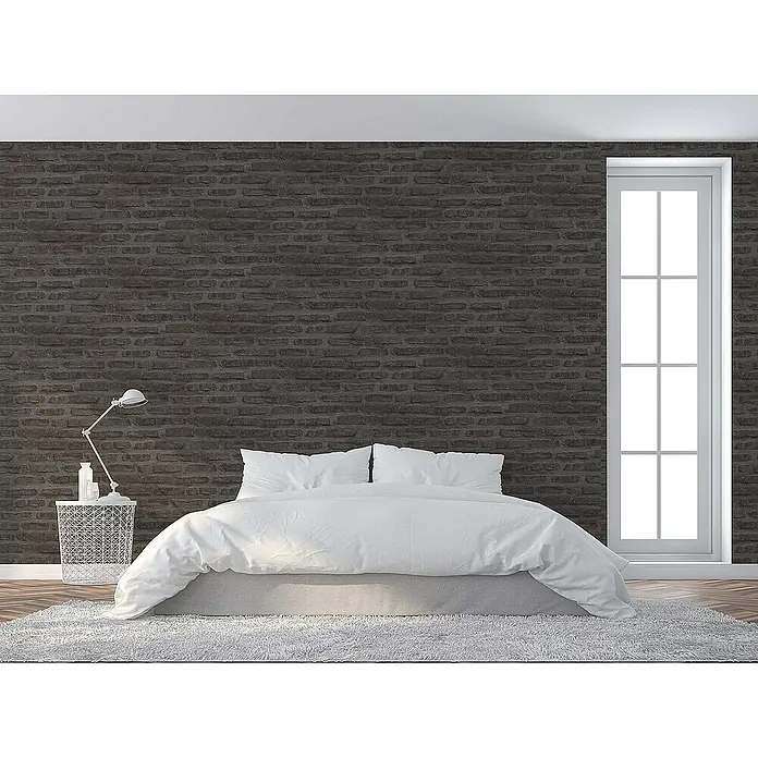 Tadessi Vliestapete M1-No.419 - Schwarz, Steinoptik, 10,05 x 0,53 m - Dunkelgraue Tapete mit Ziegelmuster an einer Schlafzimmerwand, die eine strukturierte, industrielle Optik hinter einem weißen Bett und Fenster schafft.