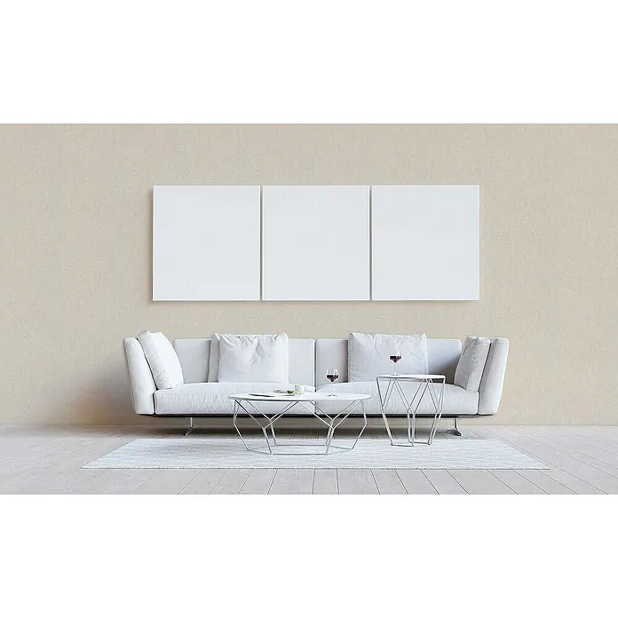 Tadessi Vliestapete M1-No.1815 - Creme, Steinoptik, 10,05 x 0,53 m - Drei leere weiße Leinwände hängen über einem weißen Sofa in einem minimalistischen Wohnzimmer.