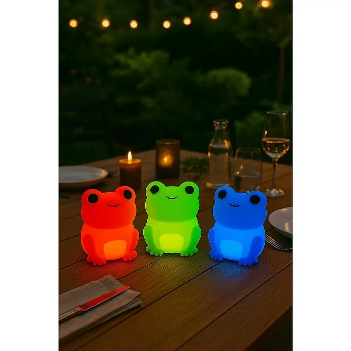 FHL easy LED-Nachtlicht Willi - 0,4 W, L x B x H: 9 x 8 x 11,5 cm, RGBW, Frosch Willi - Drei LED-Froschlampen in Rot, Grün und Blau auf einem Tisch mit Geschirr und Kerzen sorgen für eine stimmungsvolle Beleuchtung im Garten.