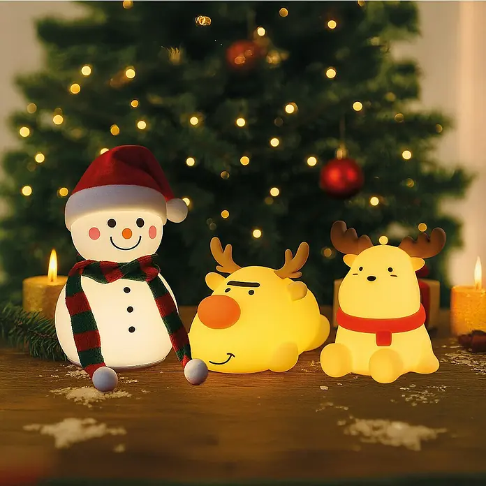 FHL easy LED-Nachtlicht Rudi - L x B x H: 16 x 10,5 x 9,8 cm, Warmweiß, Rentier Rudi - Weihnachtliche Szene mit einem leuchtenden Schneemann, zwei Rentieren und einem festlich geschmückten Weihnachtsbaum im Hintergrund.