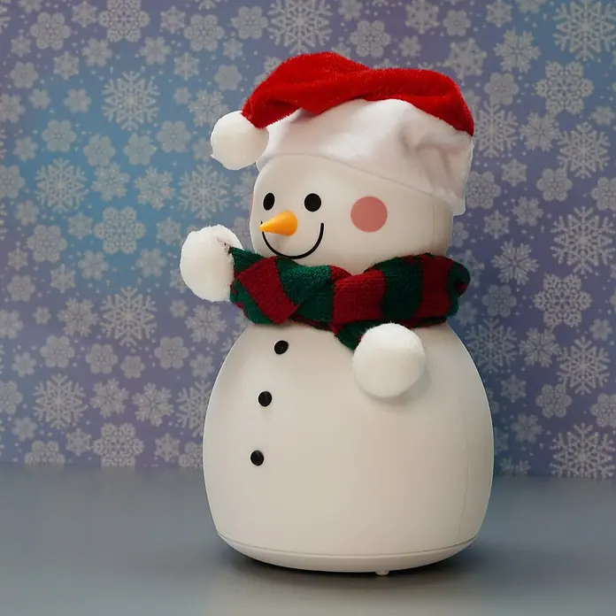 FHL easy LED-Nachtlicht Paule - 0,4 W, L x B x H: 11,6 x 11,6 x 22 cm, RGBW, Schneemann Paule - Eine festliche Schneemannfigur mit roter Mütze und gestreiftem Schal vor einem verschneiten Hintergrund.