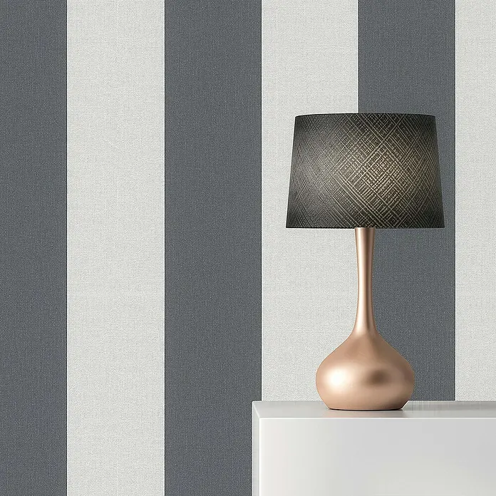 Tadessi Vliestapete M1-No.12 - Grau, Streifen, 10,05 x 0,53 m - Elegante Tischlampe mit kupferfarbenem, bauchigem Fuß und dunklem, gemustertem Lampenschirm, auf einer weißen Ablage.