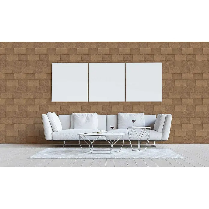 Tadessi Vliestapete M1-No.3393 - Braun, Steinoptik, 10,05 x 0,53 m - Braune Wandverkleidung im Ziegelstein-Stil in einem Wohnzimmer mit weißem Sofa und drei leeren weißen Leinwänden.