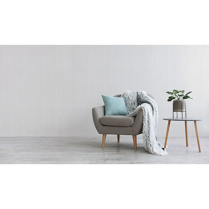 Tadessi Vliestapete M1-No.2055 - Weiß, Streifen, 10,05 x 0,53 m - Stilvoller grauer Sessel mit blauem Kissen und flauschiger Decke, neben Beistelltisch mit Pflanze.