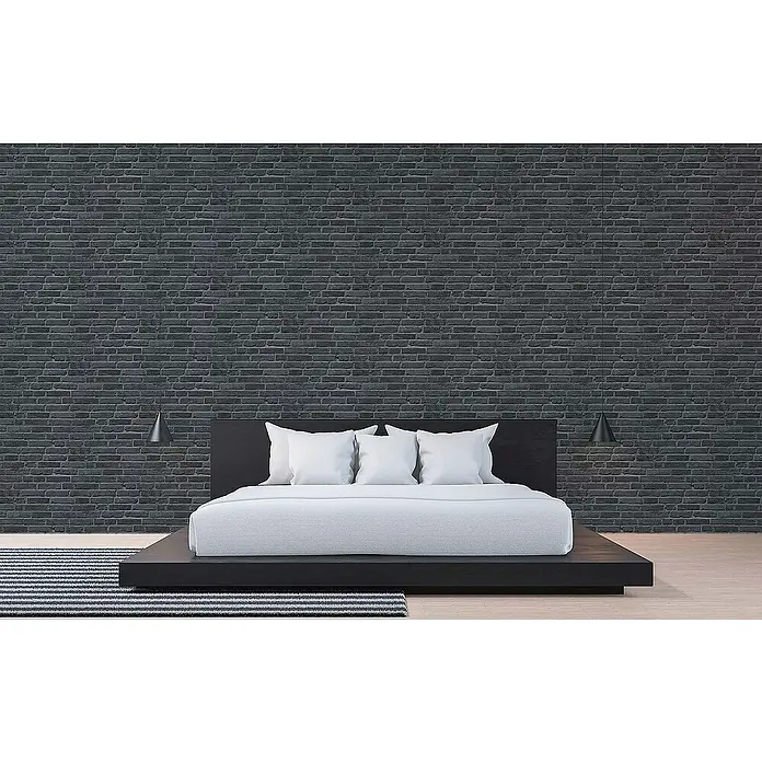 Tadessi Vliestapete M1-No.890 - Schwarz, Steinoptik, 10,05 x 0,53 m - Modernes schwarzes Plattformbett mit weißer Bettwäsche in einem minimalistischen Schlafzimmer mit dunkler Ziegelwand.