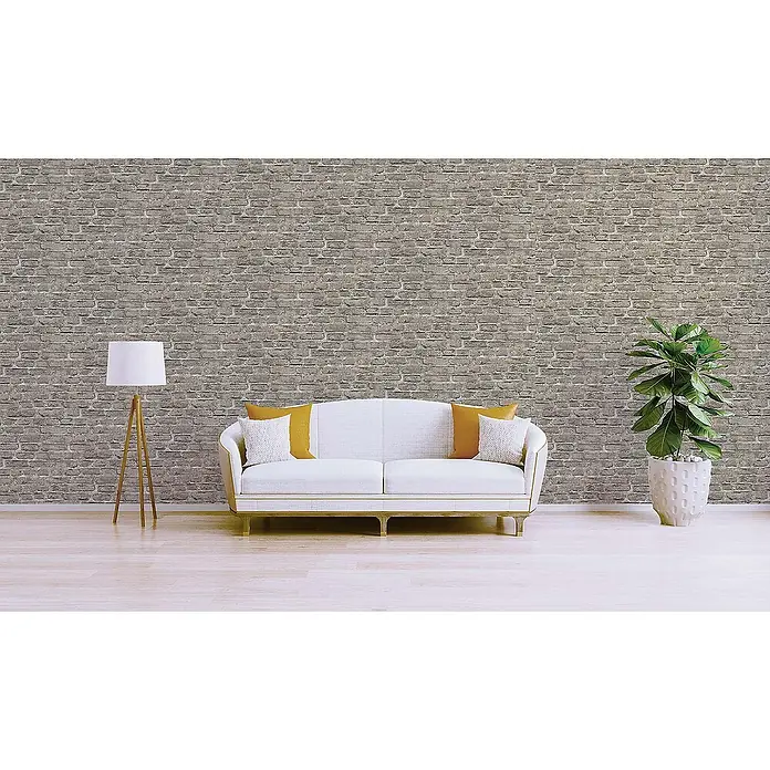 Tadessi Vliestapete M1-No.160 - Grau, Steinoptik, 10,05 x 0,53 m - Graue Ziegelwandverkleidung als Blickfang in einem modernen Wohnzimmer mit weißem Sofa, Lampe und Pflanze.