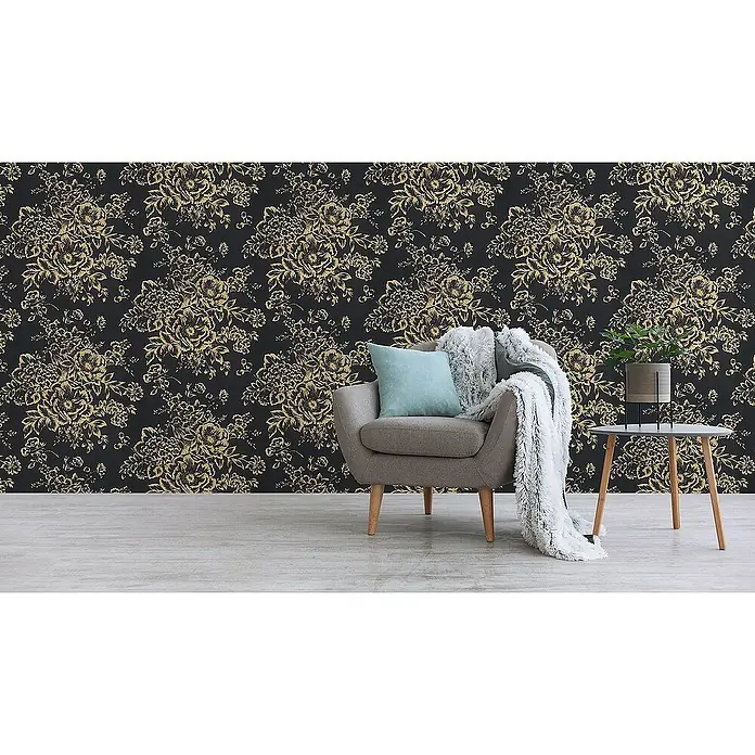 Tadessi Vliestapete M1-No.2169 - Schwarz, Floral, 10,05 x 0,53 m - Schwarze Tapete mit goldenem Blumenmuster an einer Wand, die einen Raum mit Sessel und Beistelltisch aufwertet.