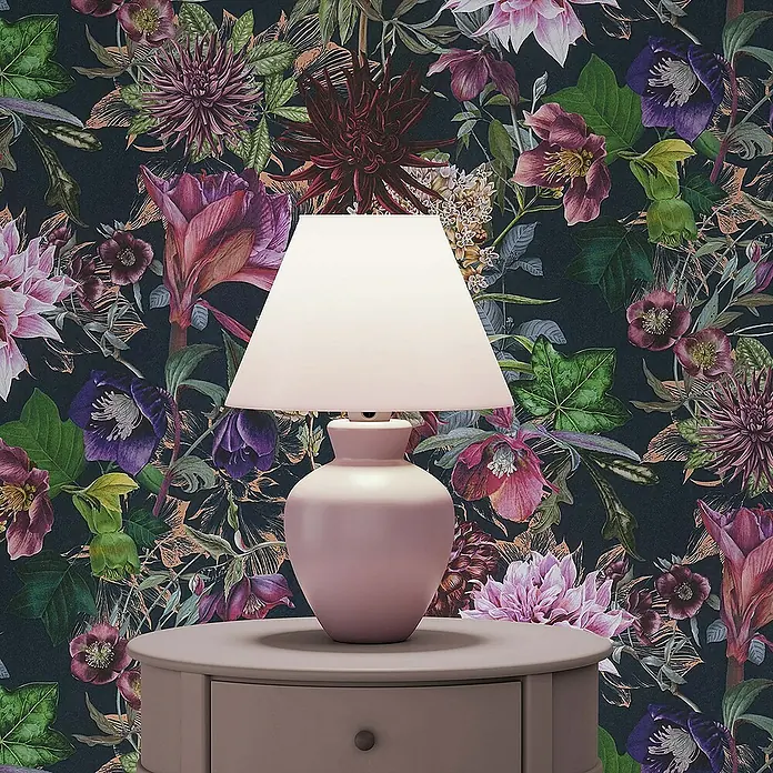 Tadessi Vliestapete M1-No.777 - Schwarz, Floral, 10,05 x 0,53 m - Rosa Tischlampe mit hellem Schirm, auf einem runden Tisch vor einer dunklen Blumenwand platziert.