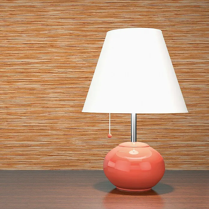 Tadessi Vliestapete M1-No.1369 - Orange, Streifen, 10,05 x 0,53 m - Eine Tischlampe mit weißem Schirm und glänzendem korallenfarbenem Kugelsockel steht auf einem Holztisch.