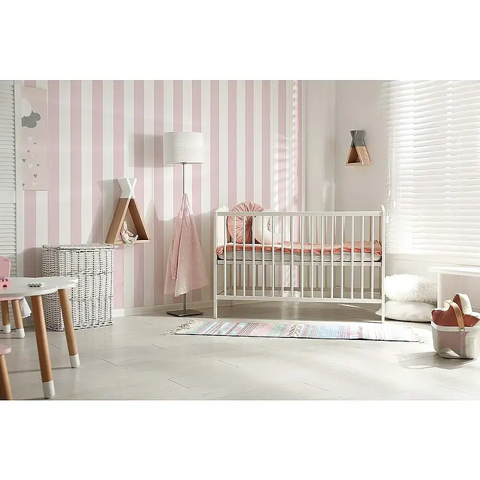 Tadessi Vliestapete M1-No.768 - Rosa, Streifen, 10,05 x 0,53 m - Weißes Holzbettchen mit rosa Bettwäsche in einem charmanten Kinderzimmer mit gestreifter Tapete.