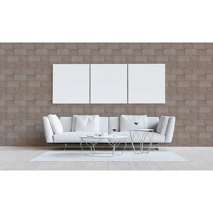 Tadessi Vliestapete M1-No.3392 - Braun, Steinoptik, 10,05 x 0,53 m - Drei leere weiße Leinwände hängen über einem weißen Sofa in einem modernen Wohnraum.