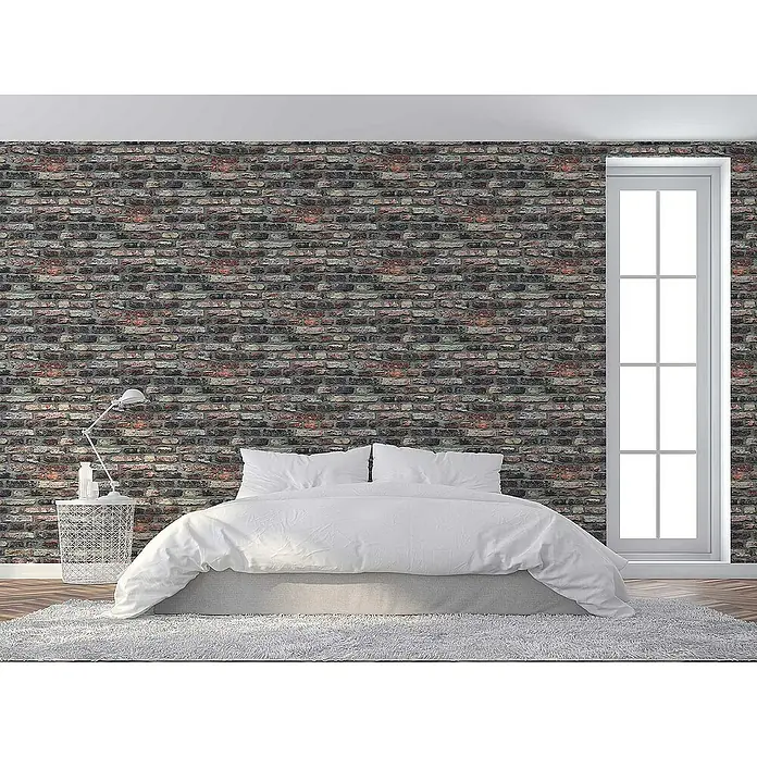 Tadessi Vliestapete M1-No.2661 - Grau, Steinoptik, 10,05 x 0,53 m - Rustikale, mehrfarbige Ziegelstein-Tapete als Akzentwand in einem Schlafzimmer mit weißem Bett und hohem Fenster.