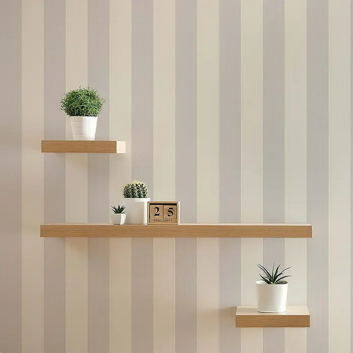 Tadessi Vliestapete M1-No.596 - Grau, Streifen, 10,05 x 0,53 m - Drei schwebende Regale aus hellem Holz an einer gestreiften Wand, mit Pflanzen und einem Kalenderblock.