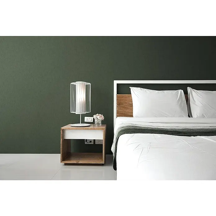 Tadessi Vliestapete M1-No.3142 - Grün, Uni, 10,05 x 0,53 m - Ein modernes Bett mit weißer Bettwäsche und Holzkopfteil, daneben ein passender Holznachttisch mit einer weißen Lampe.