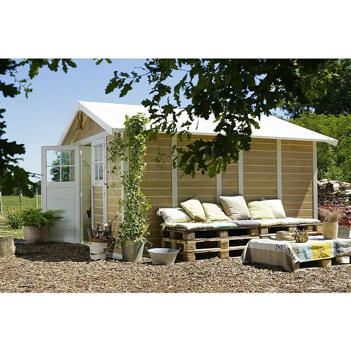 Grosfillex Caseta para jardín Deco - Medidas ext. (An x Pr): 315 x 357 cm, Plástico, Blanco/Efecto madera, 11 m² - Acogedora zona de jardín con una caseta de madera, muebles de palets y vegetación exuberante, ideal para relajarse al aire libre.