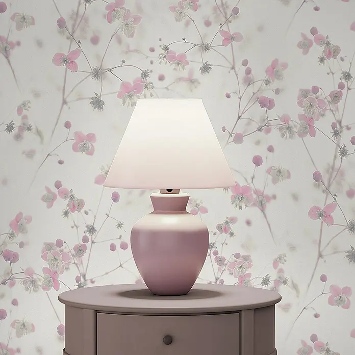 Tadessi Vliestapete M1-No.3574 - Rosa, Floral, 10,05 x 0,53 m - Rosafarbene Tischlampe mit weißem Schirm auf passendem Rundtisch vor floraler Tapete.