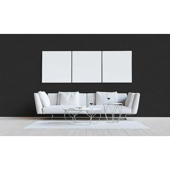 Tadessi Vliestapete M1-No.1965 - Schwarz, Steinoptik, 10,05 x 0,53 m - Drei leere weiße Leinwände an einer dunklen Wand über einem Sofa.