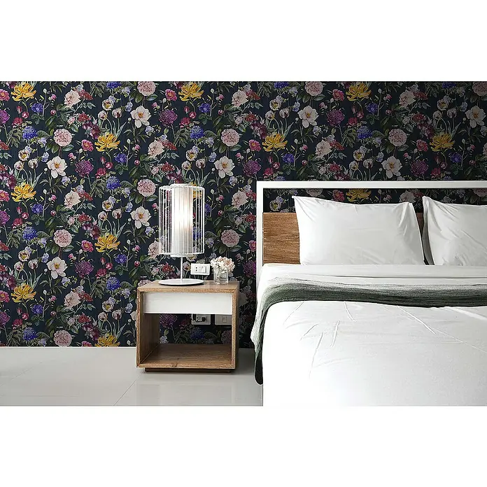 Tadessi Vliestapete M1-No.348 - Blau, Floral, 10,05 x 0,53 m - Dunkle Blumentapete mit leuchtenden farbigen Blumen wie Gelb, Rosa und Lila, die eine Schlafzimmerwand hinter einem Bett schmückt.